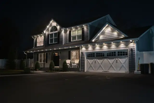 White house with permanent warm-white roofline lighting at night